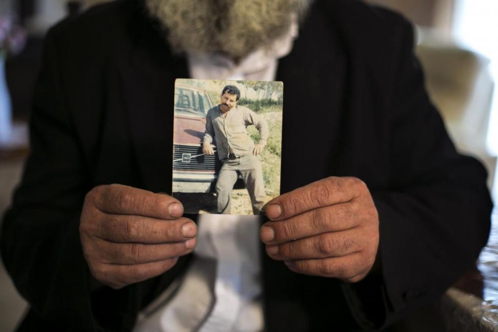 Rabbi Avraham Sinai shows a photo from his past in his home in the northern Israeli town of Safed, October 5, 2014. REUTERS/Baz Ratner