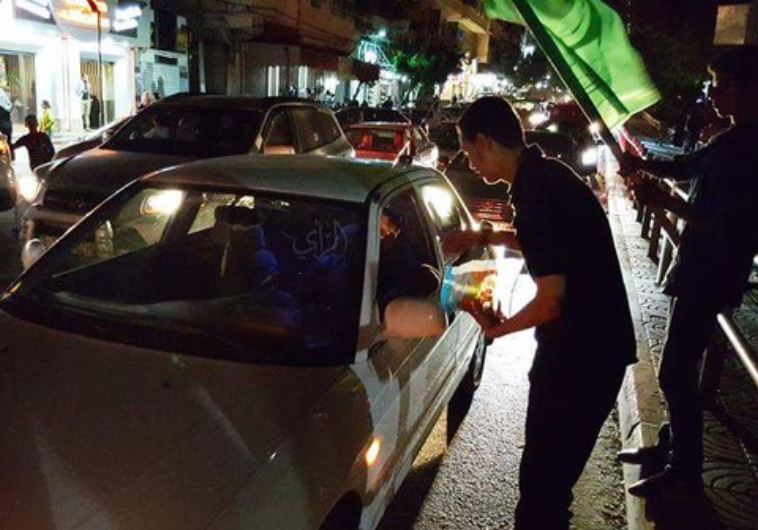 Fiatal arab fiú cukorkát osztgat Tulkaremben egy merénylet után