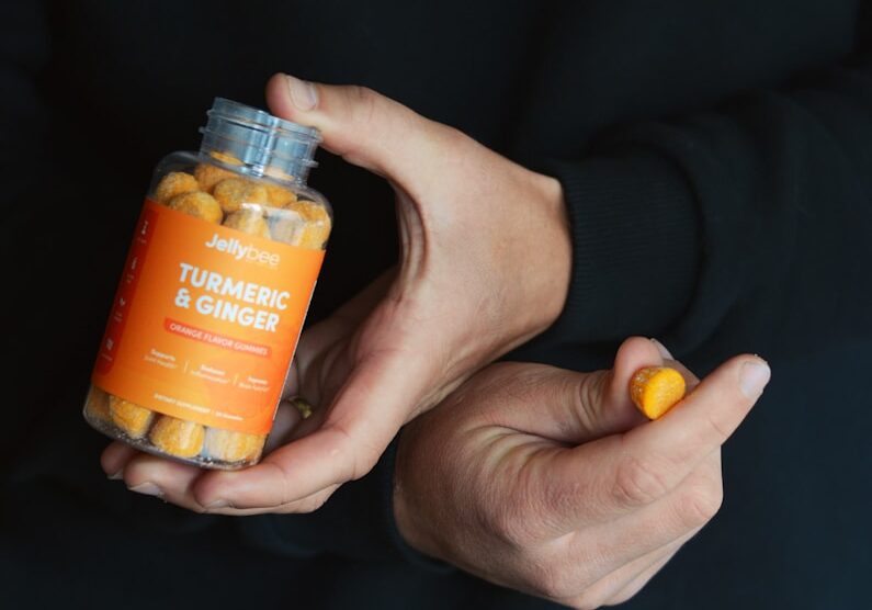 person holding orange plastic bottle