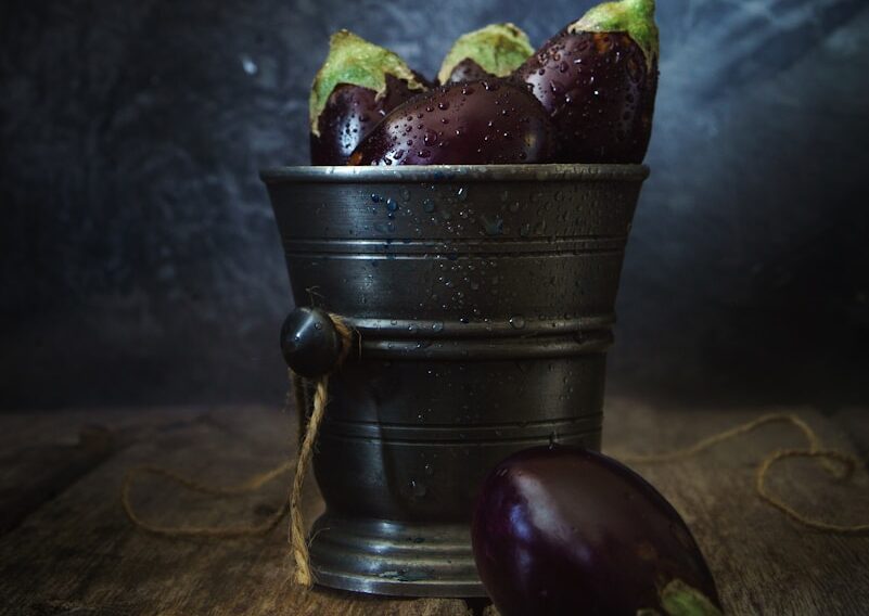 green and red fruit on black metal bucket